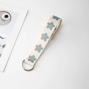 Close-up of canvas belt with blue flower patterns and silver double D-ring buckle
