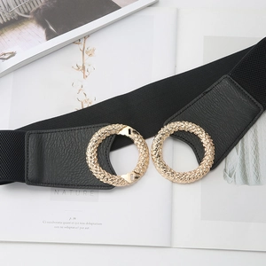 Women's black elastic wide belt with golden textured double ring buckle on a magazine