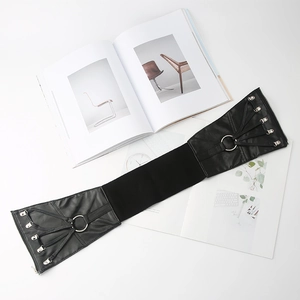 Détail d'une large ceinture corset élastique noire avec laçage et boucles en métal