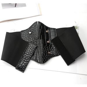 Elastic wide black waist belt with crocodile texture and gold rivets on a white background