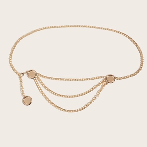 Detailed close-up of golden metal chain belt with multi-layer tassel and glossy round buckles