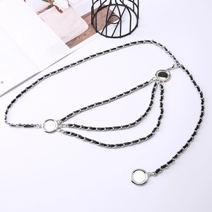 Detailed macro view of multi-layered silver metal chain belt with woven black leather accents