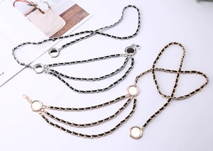 Detail of woven metal waist chains in gold and silver with leather interlaced strands