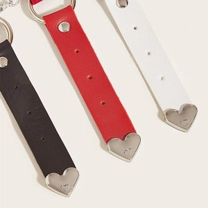 Detail of adjustable leather garters in black, red, and white with metal heart charms