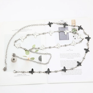 Detail of metal waist chain with black and white butterfly charms and rhinestone accents