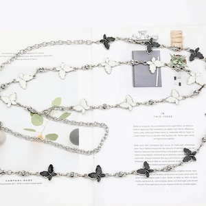 Detail of silver butterfly chain belt with enamel accents and sparkling rhinestones