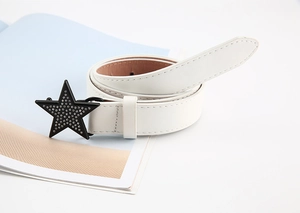Détail de la fine ceinture en cuir blanc avec boucle étoile noire sertie de strass