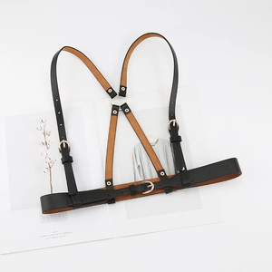 Adjustable black leather body harness with silver metal buckles on a white background