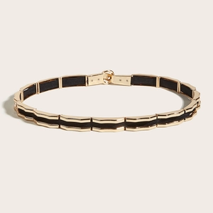 Modern gold geometric waist belt with black elastic fabric and circular buckle