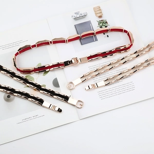 Detailed shot of elastic waist belt with gold metal links and chic ring buckle