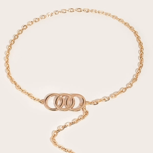 Détail d'une ceinture chaîne dorée à maillons avec trois anneaux métalliques superposés