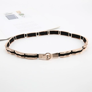 Detail view of ladies black elastic belt with gold metal plates and round buckle closure