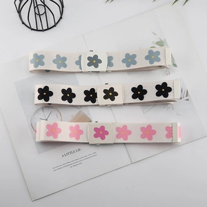Détail de trois ceintures en toile avec motifs floraux en bleu, noir et rose élégant