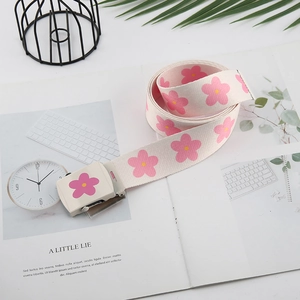 Détails de la ceinture en toile crème avec motifs floraux roses et boucle carrée élégante