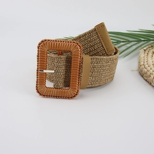 Detail view of khaki woven belt with large rectangular buckle and textured vertical stripes