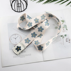 Gros plan sur une ceinture en toile à motif floral bleu avec boucle carrée assortie