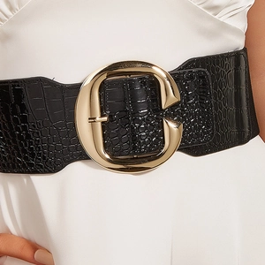 Detail of wide black crocodile pattern leather belt with large gold C-shape buckle