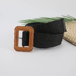 Detail of black woven bohemian belt with a large wood-textured rectangular buckle