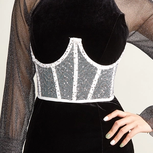 Détails de la robe en velours avec taille corset à paillettes et manches en maille