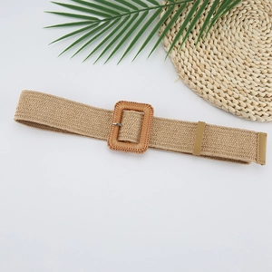 Detail of light camel woven elastic belt with a rectangular buckle on a decorative mat