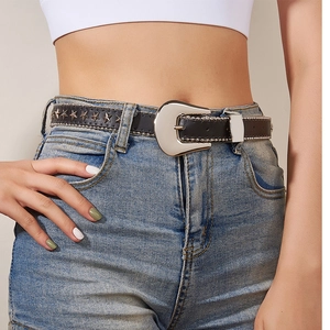Detail of a black leather belt with silver star studs on blue jeans for women