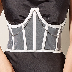 Détail de la ceinture corset avec baleines blanches, mesh gris et chaînes argentées