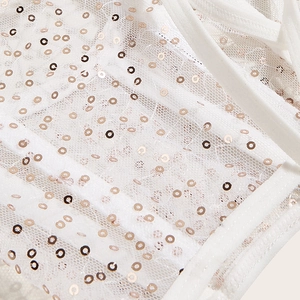 Détail du tissu en mesh blanc avec paillettes rose doré sur un corset serre-taille