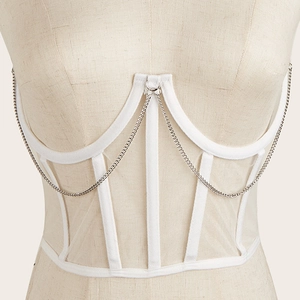 Détail de la ceinture corset en mesh blanc avec éléments décoratifs de chaîne argentée