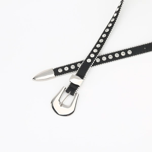 Detail of Y2K western style thin black leather belt with rhinestones and silver carving