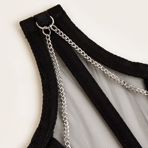 Détail d'un corset noir avec panneaux en maille et maillons de chaîne en argent