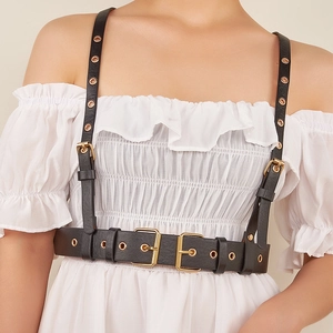 Harnais de corps punk en cuir PU noir avec boucles dorées sur une chemise blanche