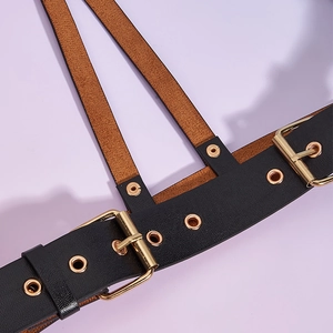 Vue macro d'une ceinture harnais en cuir punk avec boucles dorées et détails d'œillets