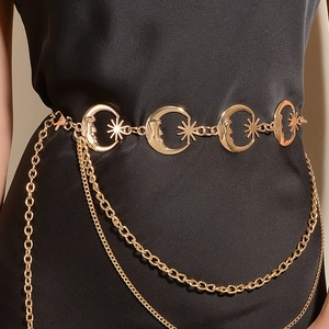 Detailed gold metal waist chain with moon and star pendants on a black dress