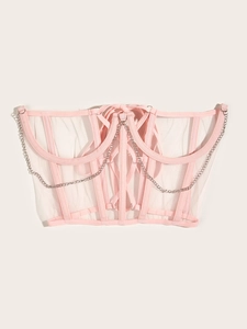 Détail d'un top corset en tulle rose avec chaînes argentées et baleines de maintien
