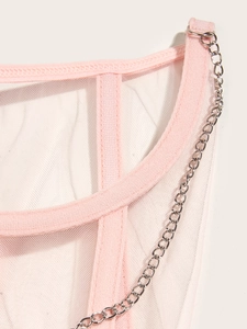 Détail macro d'un corset en maille rose avec chaîne en métal argenté et coutures fines