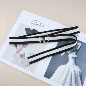 Striped canvas belt with metal D-ring buckle on a fashion magazine background