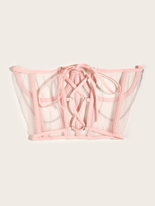 Détail du corset en résille rose montrant les baleines, le laçage et les chaînes