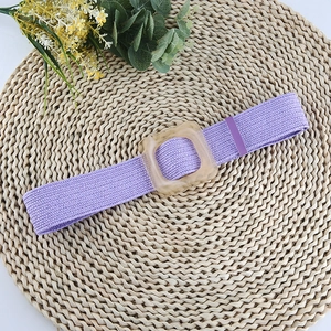 Ceinture tressée élastique violette avec boucle carrée en résine ambrée sur paille