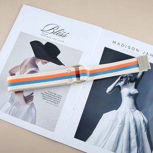 Striped canvas belt with double D-ring buckle on fashion magazine, stylish unisex accessory