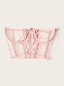 Détail d'un corset en maille rose avec laçage frontal et baleines verticales