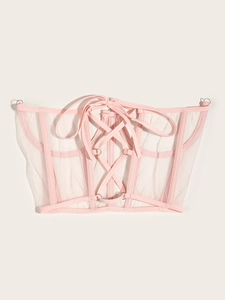Détail du laçage arrière d'une ceinture corset en maille rose avec rubans et œillets