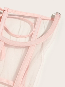 Détail du haut corset en maille rose montrant la structure baleinée et l'anneau en métal