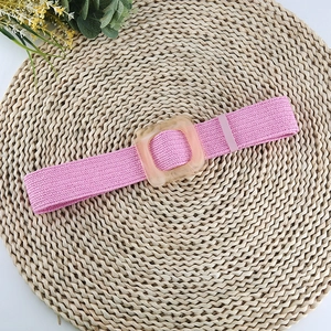 Détail de la ceinture tressée rose élastique avec une boucle carrée en résine