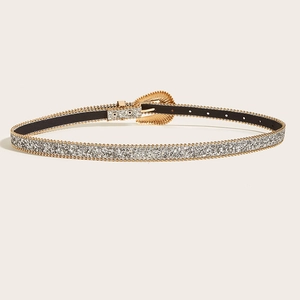Détail d'une ceinture argentée pailletée avec perles dorées et boucle style western