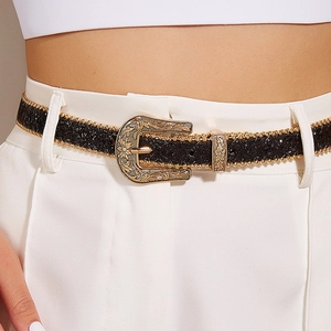 Détail de la boucle en métal gravé sur ceinture noire pailletée avec bordure perlée dorée