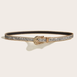 Détail d'une ceinture fine à paillettes argentées avec boucle dorée ciselée