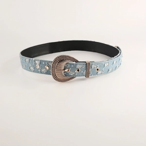 Dettaglio della cintura in denim azzurro con paillettes e fibbia vintage incisa