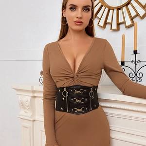 Dettaglio di una cintura a corsetto nera con fibbie dorate e borchie a stella da donna