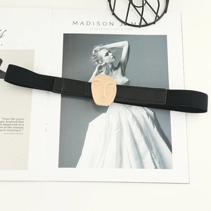 Elastic black waist belt for dresses with a gold abstract face metal buckle design