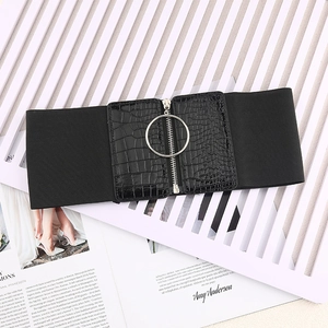 Détail d'une ceinture corset élastique noire avec texture crocodile et zip à anneau argenté